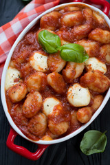 Wall Mural - Close-up of potato gnocchi baked with tomato sauce and mozzarella cheese, above view