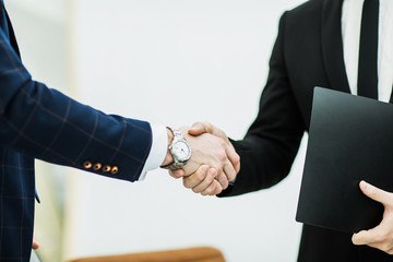 handshake of business partners on the background of the office