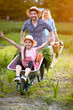 Cheerful daughter in wheelbarrow with father