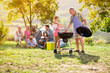 © luckybusiness - Grandfather and granddaughter at barbecue grill.