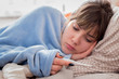 woman on bed suffering from fever. girl having a cold, with flu checking thermometer.