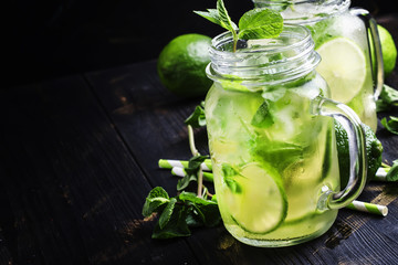 Wall Mural - Green tea with mint and ice, black background, selective focus