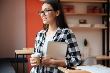 Sticker - Young caucasian woman using tablet computer and holding coffee.