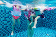 Leinwandbild Motiv Underwater pohto of legs of the Asian Chinese family