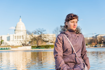 Wall Mural - Young woman sitting in front on Congress capitol building in Washington DC by reflecting pool