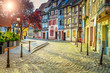 Colorful medieval half-timbered facades with paved road in Colmar