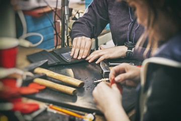 Two young womans work  with leather