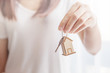 © oatawa - Female hand holding key house shaped keychain.