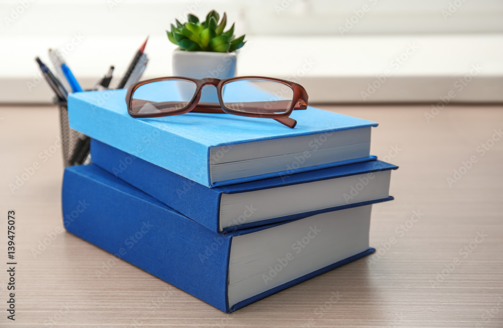 New books and glasses on wooden table