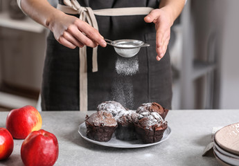 Sticker - Woman powdering chocolate muffins with sugar icing on table