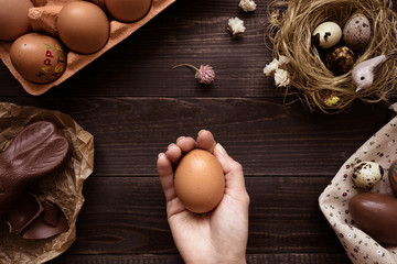 Wall Mural - female hands holding easter egg on the wooden table