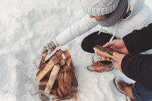 Girl And Boy Put Firewood On Snow
