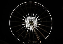 White Star Ferris Wheel Brightly Lit At Amusement Park At Night, Dark Background