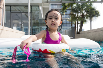 Asian Chinese little girl learning at the outdoor swimming pool