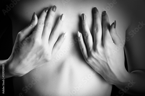 Plakat kobiece ręce obejmujące małe piersi zbliżenie monochromatyczne