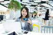 © leungchopan - Businesswoman working on laptop computer and drinking of coffee in co-working space