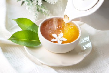 Close up pouring hot jasmine tea in a white tea cup ,  Tea ceremony time concept