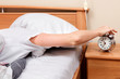 © Nobilior - Woman turning off her alarm clock in her bedroom