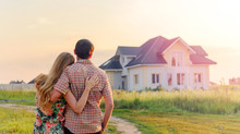 Young Couple Standing Outside Dream Home