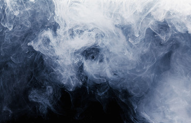 Abstract cloud pattern of white smoke on a black background.