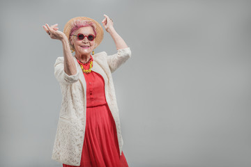 Happy beautiful senior lady wearing sunglasses and hat