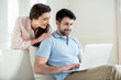 © LIGHTFIELD STUDIOS - portrait of woman looking at man using laptop at home