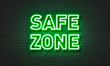 Safe zone neon sign on brick wall background.