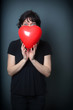 © mvc_stock - Woman holding a heart Balloon on a Grey Background, playing Peekaboo