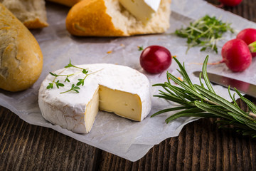 Cheese with white mold, radish, grapes and baguette with herbs