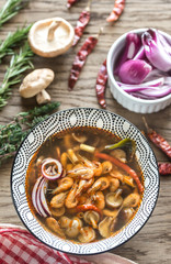 Wall Mural - Bowl of thai tom yum soup on the wooden background