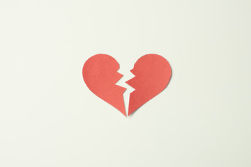 Red paper broken heart on white background