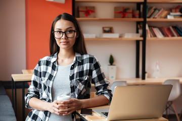 Sticker - Pretty young caucasian lady using laptop and drinking coffee.