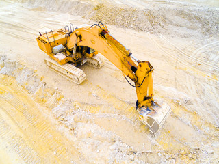 Wall Mural - Aerial view of a working excavator in the clay open cast mine. Heavy industry from above. Industrial background from devastated landscape. 