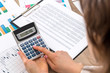 © RomanR - Woman calculate about expenses at office.