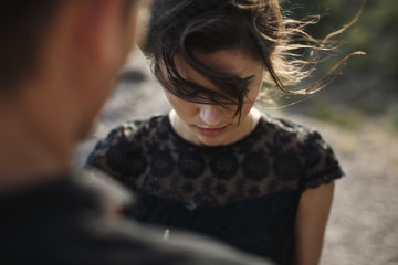 Woman and man in black clothes outdoors. Black wedding dress.