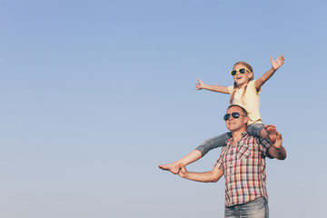 Sticker - Dad and daughter in sunglasses playing in the park at the day time.