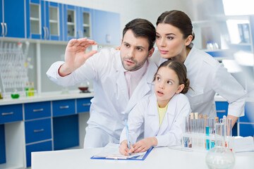 Wall Mural - portrait of concentrated scientists looking at microscope slide in lab