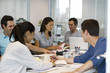 © PhotoAlto - Business people talking while sitting at table in meeting