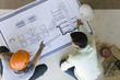 © PhotoAlto - Two men reviewing blueprint spread out on floor