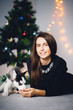 © Parilov - Girl on the background of a Christmas tree with a puppy of a husky. Dog black and white with blue eyes. Concept gift for the new year dog.
