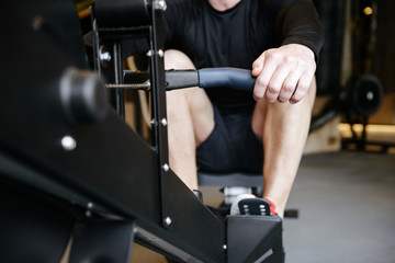 Cropped image of Muscular man using rowing machine