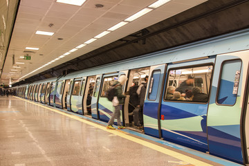 subway train station platform with people traveling