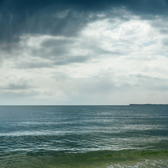 Wall Mural - low dramatic clouds over darken sea