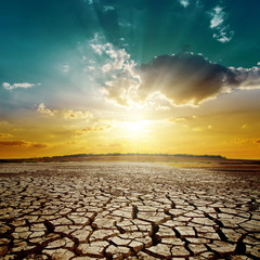 Wall Mural - orange sunset over drought earth