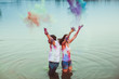 © pyrozenko13 - Man and woman in jeans splash colorful sand up standing in the water