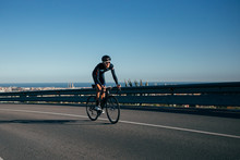 A Fit Strong Cyclist Climbs A Road Overlooking Barcelona, Spain
