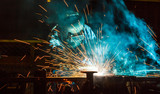 Fototapeta Tęcza - Worker,welding in a car factory with sparks, manufacturing, industry
