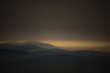 © andreiuc88 - dark landscape with mountains and hills in the distance at sunset