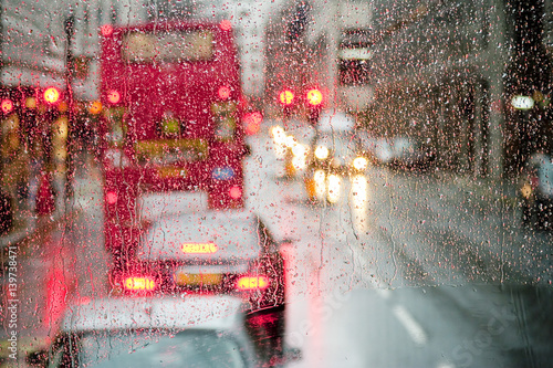 Fotomural Lluvia en Londres vista hacia el autobús rojo a través de la ventana con manchas
