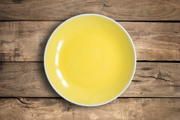 Top view of blank dish on a wood background.